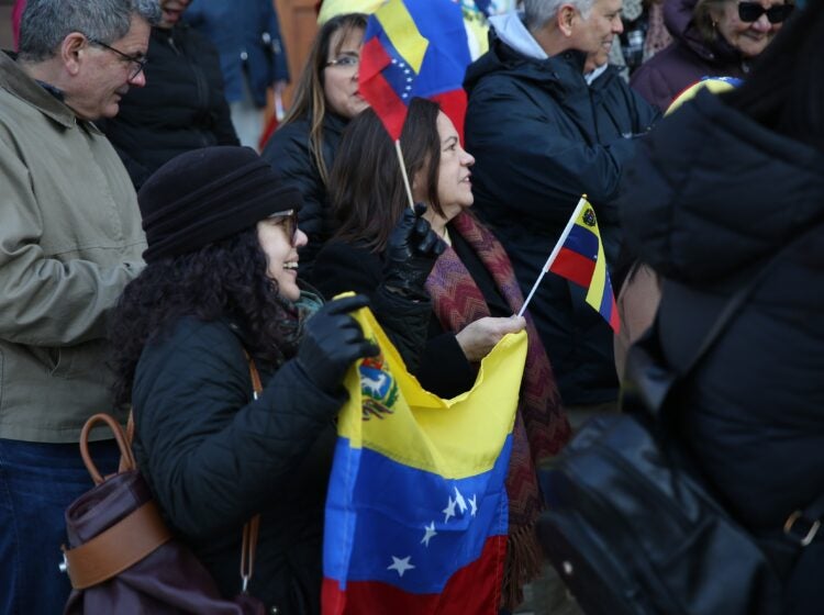 People hold Venezuelan flags outside the Cathedral Basilica of Saints Peter and Paul