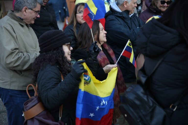 People hold Venezuelan flags outside the Cathedral Basilica of Saints Peter and Paul