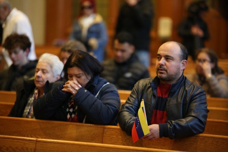 a person holds a Venezuelan flag at the Cathedral Basilica of Saints Peter and Paul