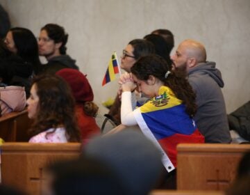 People hold Venezuelan flags at the Cathedral Basilica of Saints Peter and Paul