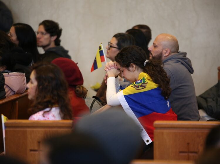 People hold Venezuelan flags at the Cathedral Basilica of Saints Peter and Paul