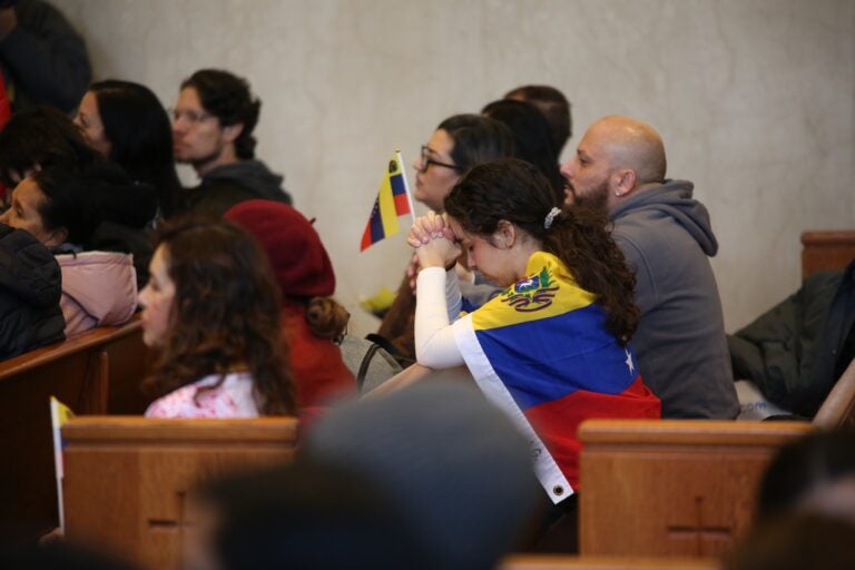 People hold Venezuelan flags at the Cathedral Basilica of Saints Peter and Paul