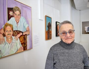 Arleen Olshan next to paintings