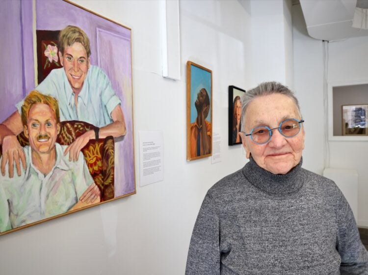 Arleen Olshan next to paintings