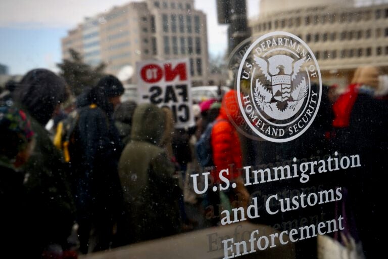Protesters are seen through the glass of an ICE office in Philadelphia