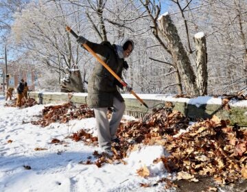 A volunteer helps clean up the 52nd Street overpass in West Fairmount Park in Philadephia