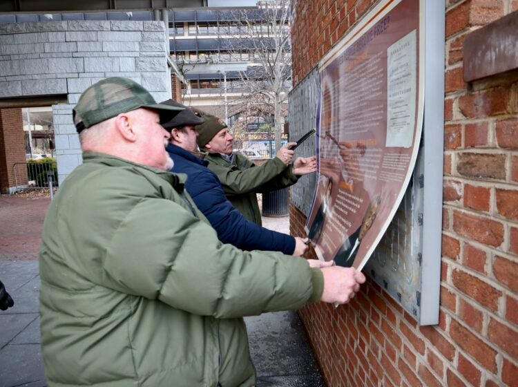 National Park Service employees remove signage related to enslaved people from the President’s House site on Independence Mall