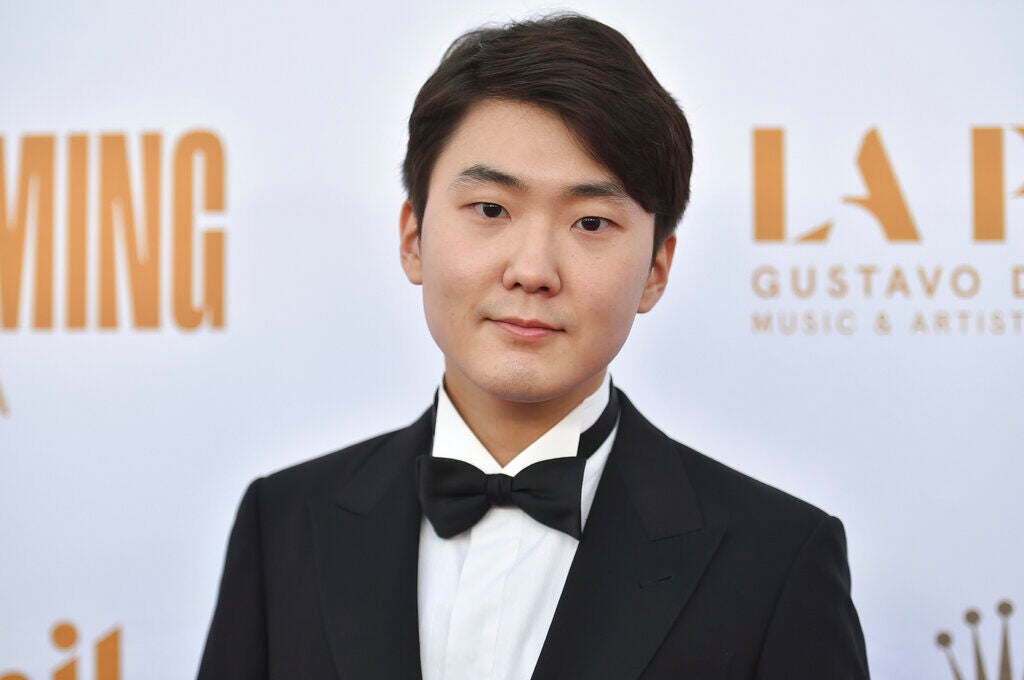 Pianist Seong-Jin Cho smiles for a picture while wearing a tuxedo