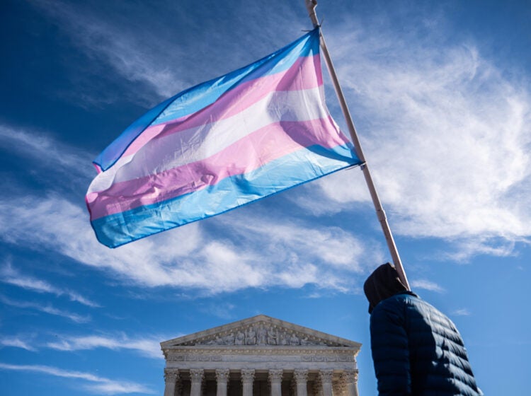 Protesters wave transgender pride flags outside the Supreme Court as it hears arguments over state laws barring transgender girls and women from playing on school athletic teams, Tuesday, Jan. 13, 2026, in Washington. (AP Photo/Julia Demaree Nikhinson)