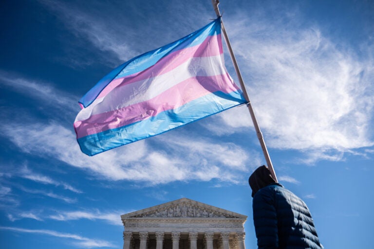 Protesters wave transgender pride flags outside the Supreme Court as it hears arguments over state laws barring transgender girls and women from playing on school athletic teams, Tuesday, Jan. 13, 2026, in Washington. (AP Photo/Julia Demaree Nikhinson)