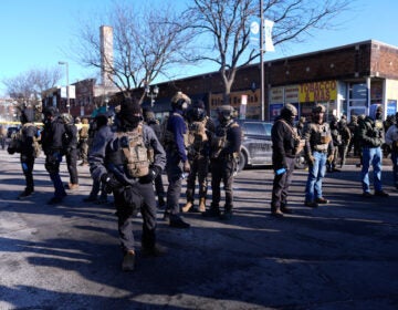 Immigration Enforcement Minnesota Federal agents stand near the site of a shooting