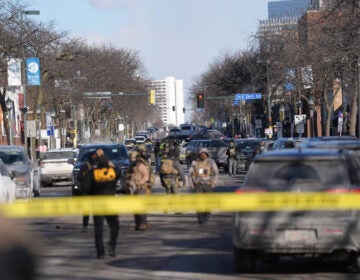 Immigration Enforcement Minnesota Federal agents stand near the site of a shooting