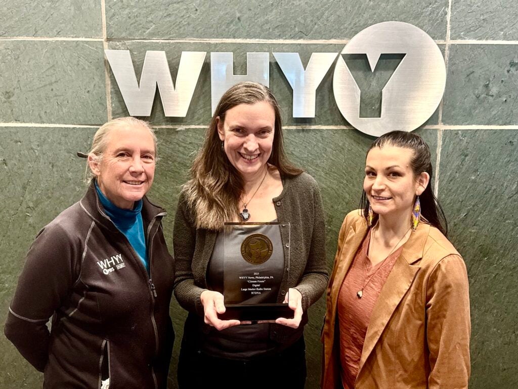 WHYY News' Emma Lee (left), Susan Phillips (center) and Kimberly Paynter pose with the 2025 National Edward R. Murrow Award for Digital for their Climate Fixers series.