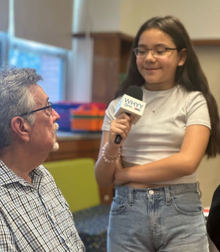 WHYY News reporter David Matthau talks with a student at a pop-up newsroom in New Jersey.