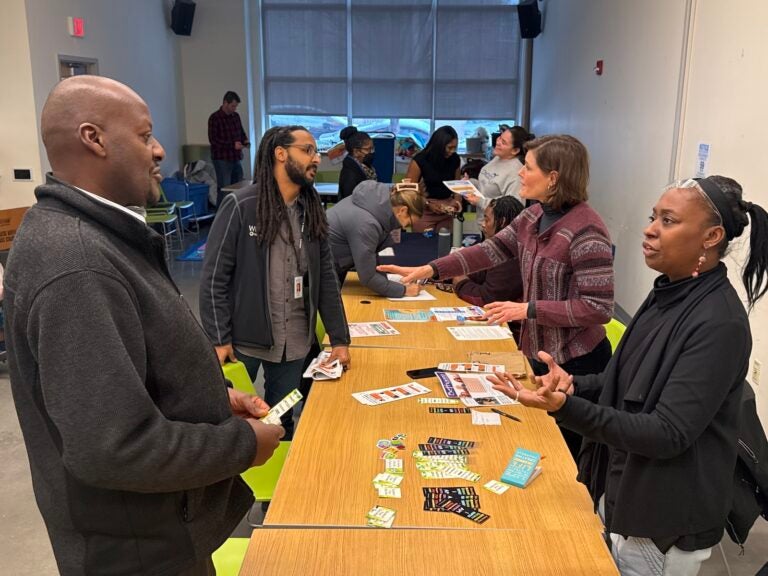 Attendees share resources at WHYY News' pop-up newsroom and foster care resource fair at the South Philadelphia Library.