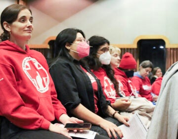 PASNAP forum 3 Health care workers and advocates sit in a forum, most wearing the same red sweater