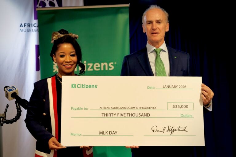 Dr. Ashley Jordan, president and CEO of the African American Museum in Philadelphia, receives a donation from Citizens Bank representative Daniel K. Fitzpatrick