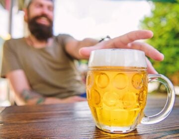 A chilled beer mug on cafe table. (photosvit/bigstock)