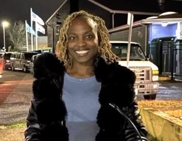 Shané Darby is smiling while standing at a podium outdoors in the evening