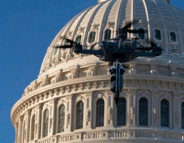 A drone tethered to a truck hovers near the U.S. Capitol