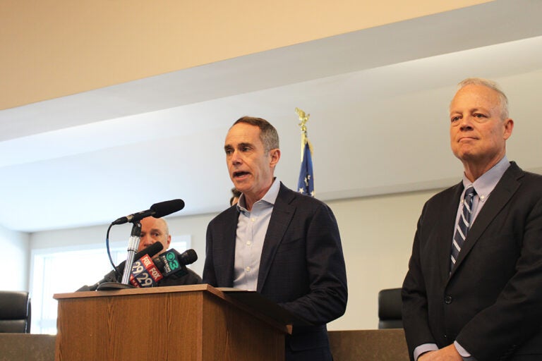 State Sen. Steve Santarsiero, left, and state Rep. Perry Warren, right, stand at a podium