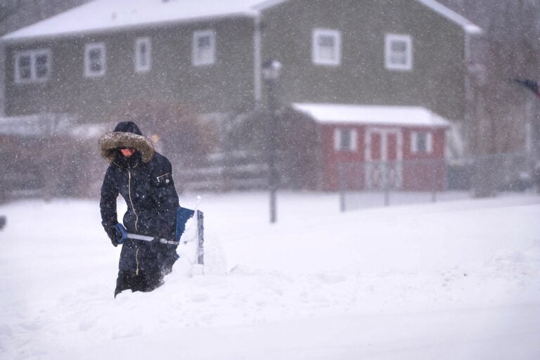 Maryann Slovin begins clearing out her driveway and sidewalk in Hockessin, Del., on Sunday, Jan. 25, 2026, as a snow storm moves through the region.