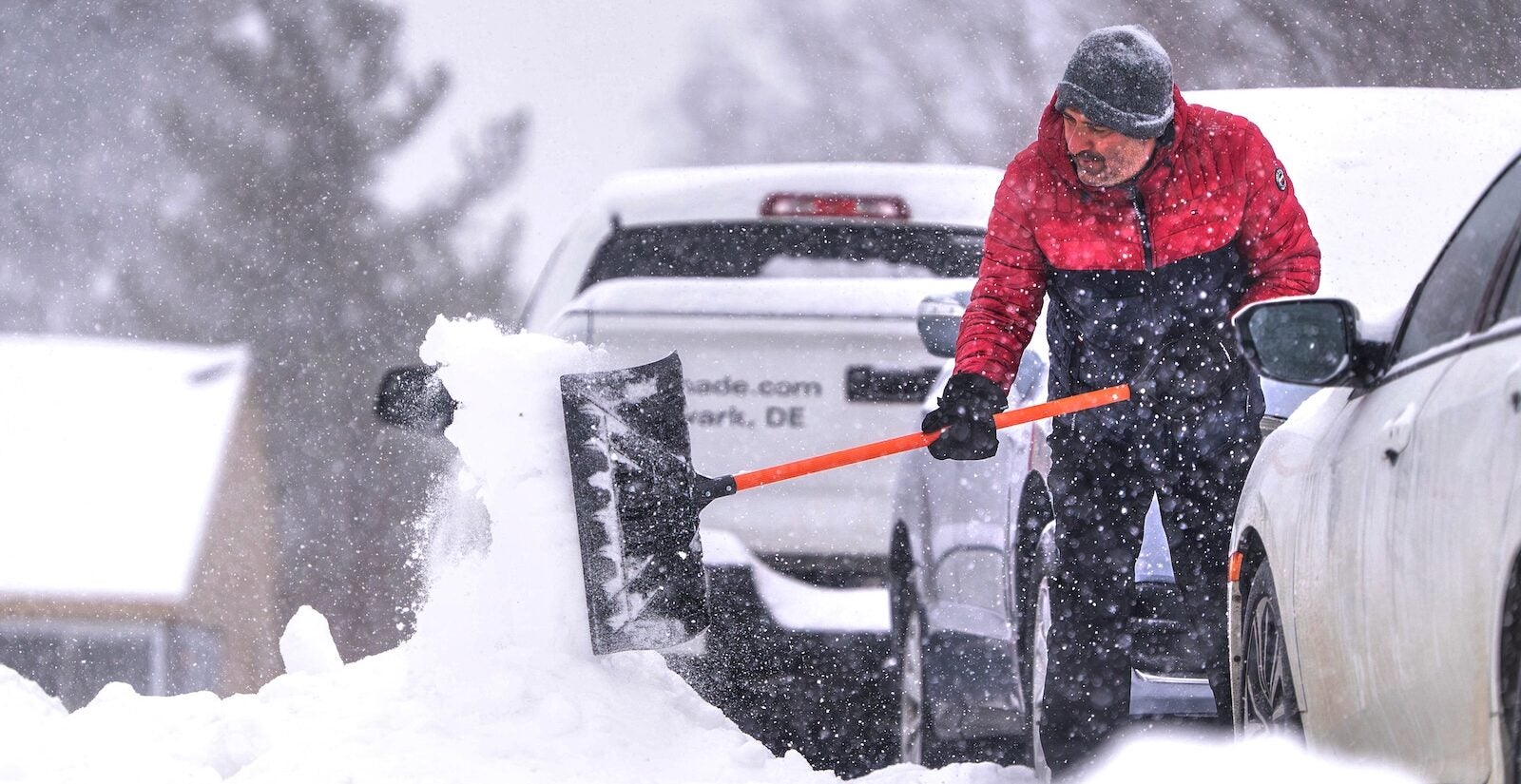 Nikos Kesidis uses a snow shovel to clear his driveway in Hockessin, Del., on Sunday, Jan. 25, 2026, as a snow storm moves through the region