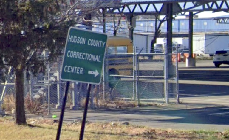 A crooked sign points people to the Hudson County Correctional Center