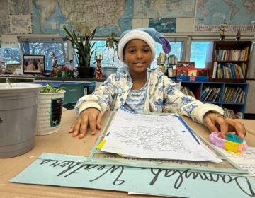 A fourth grader sits at a desk with a letter about wetland protections at Joseph M. McVey Elementary School in Newark, Delaware