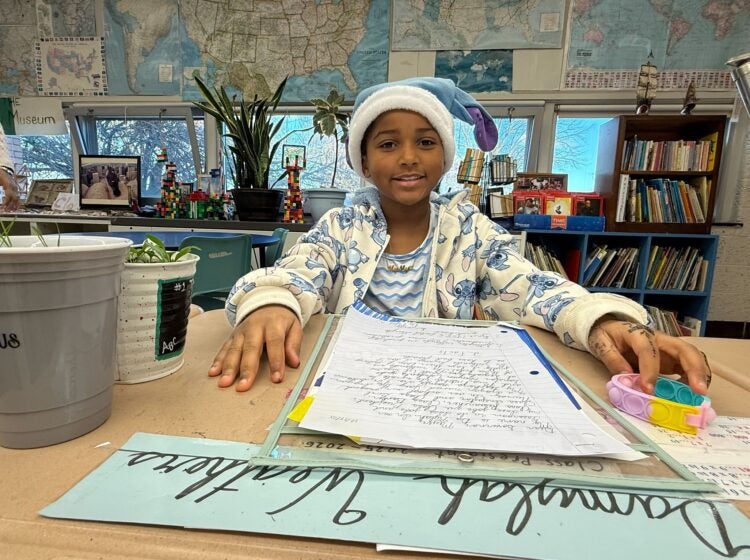 A fourth grader sits at a desk with a letter about wetland protections at Joseph M. McVey Elementary School in Newark, Delaware