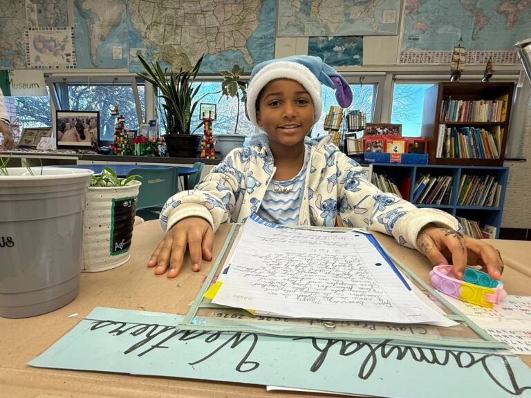 A fourth grader sits at a desk with a letter about wetland protections at Joseph M. McVey Elementary School in Newark, Delaware