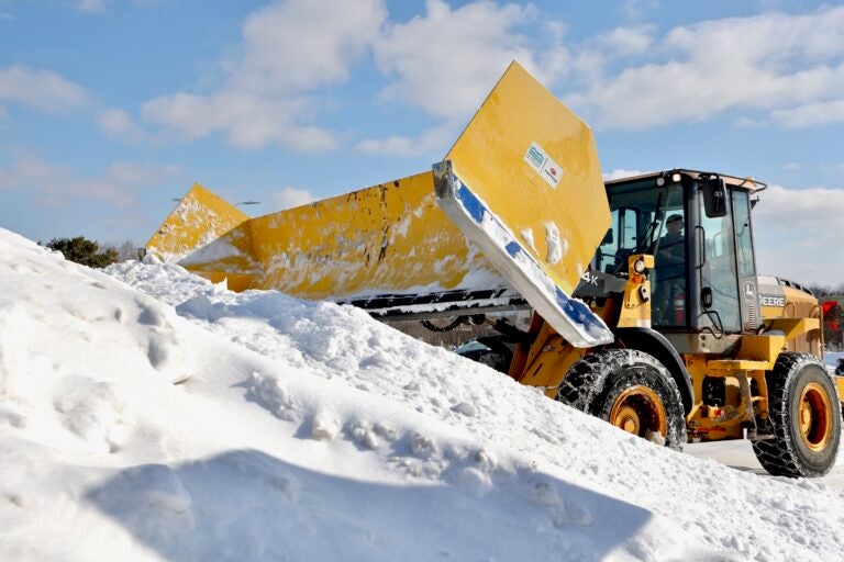 Snow piles up in great mounds as plows work to clear a parking lot in Haddonfield, N.J.