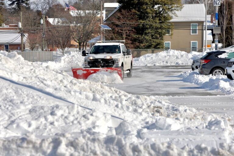 Snow piles up in great mounds as plows work to clear a parking lot in Haddonfield, New Jersey