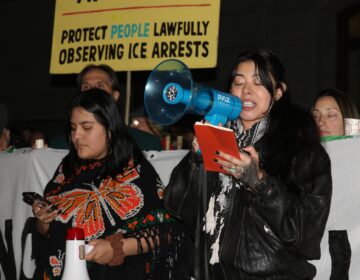 philadelphia-ice-shooting-protest-c-sharber-2026-01-08-03 A woman speaks into a megaphone at a protest in Philadelphia