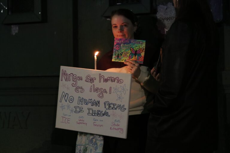 Protesters holding up signs as they gather in City Hall following the ICE shooting in Minneapolis