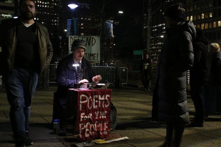 Protesters holding up signs as they gather in City Hall following the ICE shooting in Minneapolis