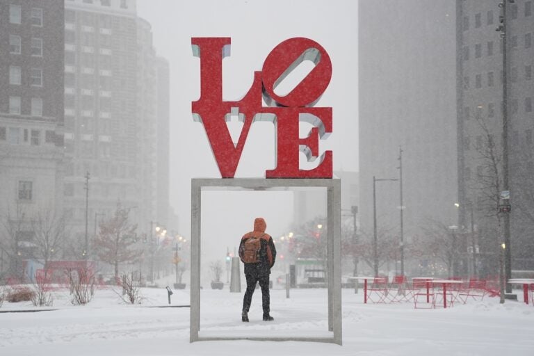 A person walks at JFK Plaza, also known as Love Park, during a winter storm in Philadelphia, Sunday, Jan. 25, 2026.