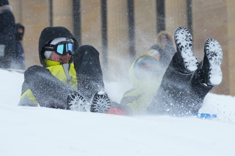 People sled on Philadelphia Art Museum steps during a winter storm in Philadelphia, Sunday, Jan. 25, 2026.