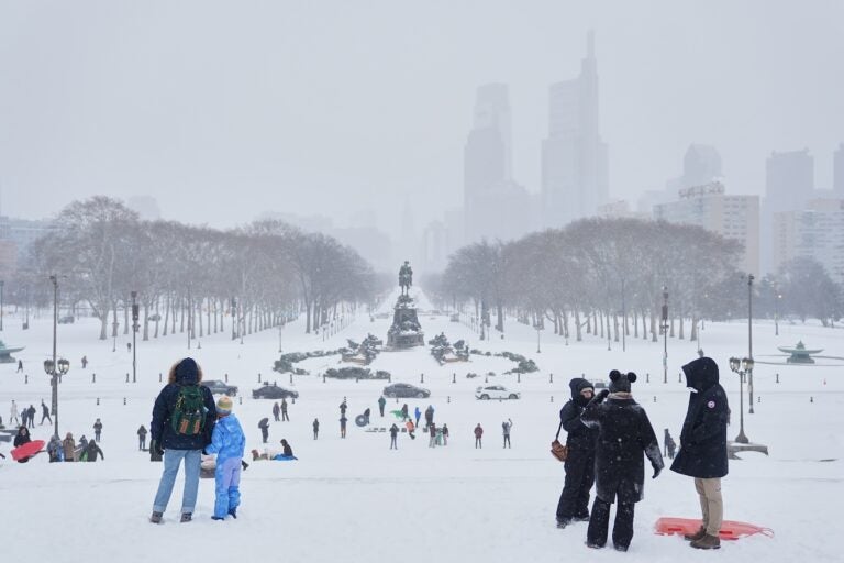 People gather at Philadelphia Art Museum steps during a winter storm in Philadelphia, Sunday, Jan. 25, 2026.
