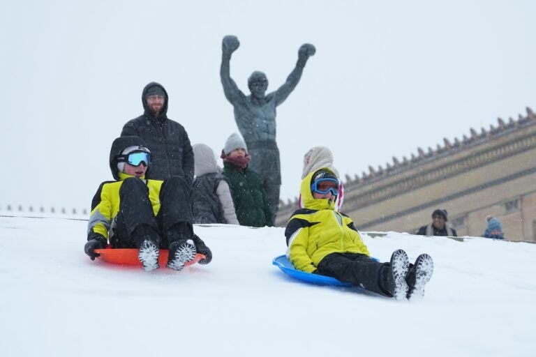 People sled on Philadelphia Art Museum steps by the Rocky statue during a winter storm in Philadelphia, Sunday, Jan. 25, 2026.