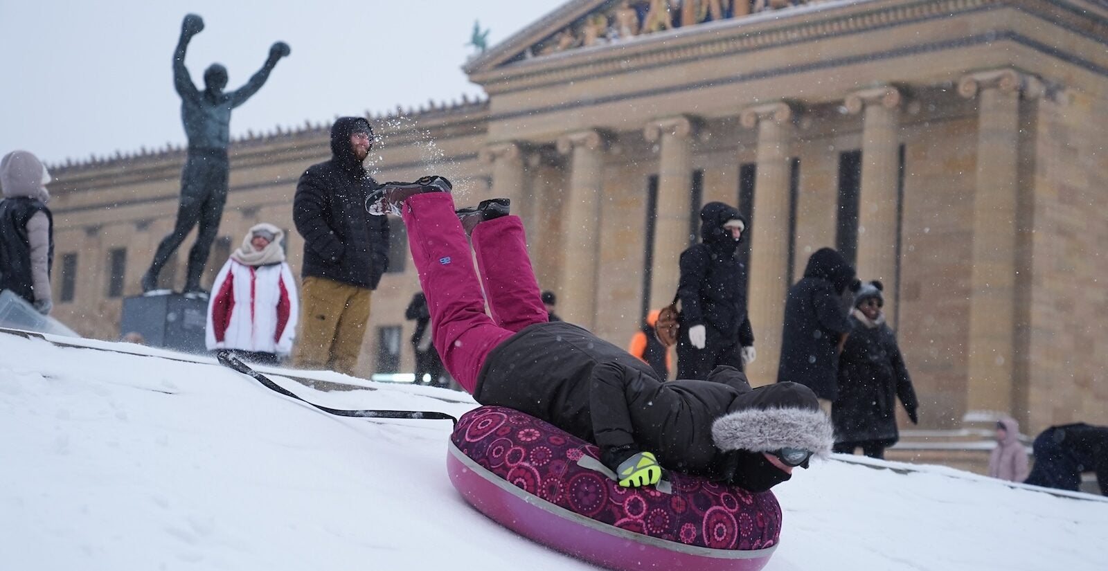 People sled on Philadelphia Art Museum steps by the Rocky statue during a winter storm in Philadelphia, Sunday, Jan. 25, 2026.