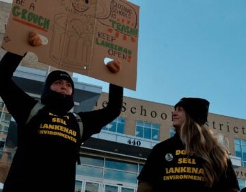 philly-school-closure-rally-b-bennett-2026-01-29-2 Two people holding up signs at a rally in front of the Philadelphia School District