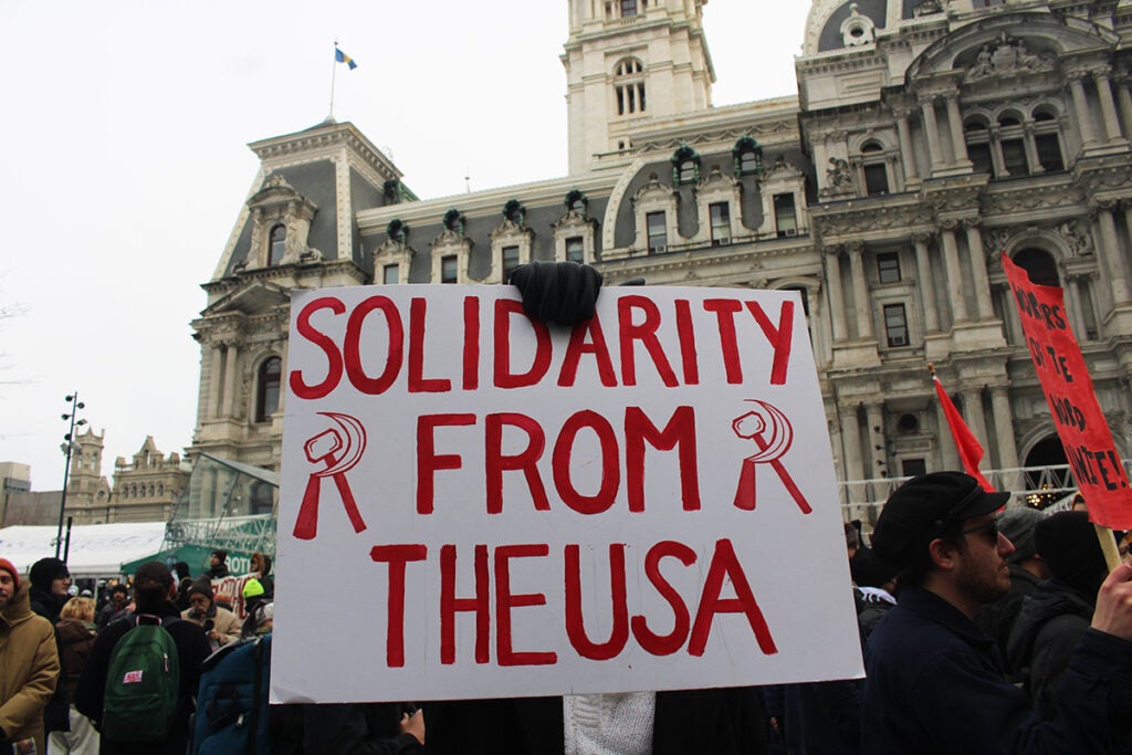 A person holds a sign "Solidarity from the USA" during a protest against the U.S. military intervention in Venezuela