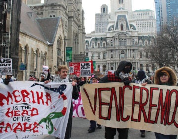 protest-4 People march in Philadelphia holding signs protesting the U.S. military intervention in Venezuela