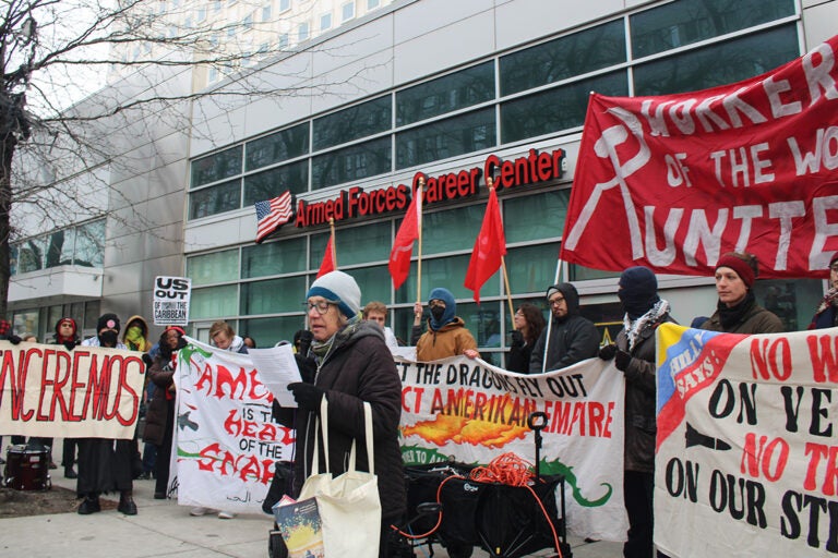 A person speaks into a microphone at a protest in Philadelphia against U.S. military intervention in Venezuela