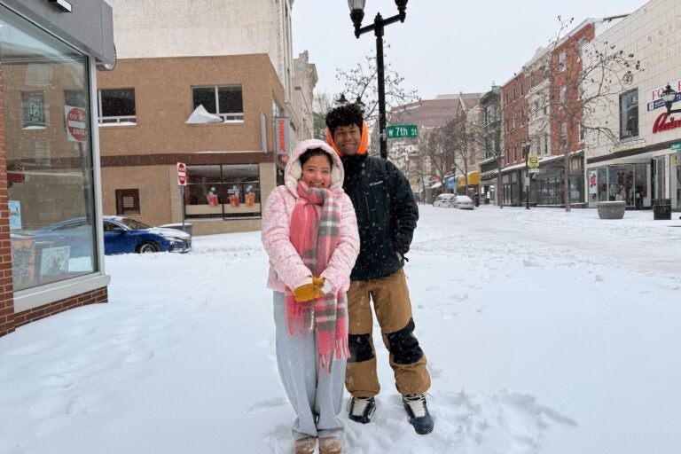 Arbee Catipay and Cortez Warren pose for a photo on a snowy Wilmington, Delaware street
