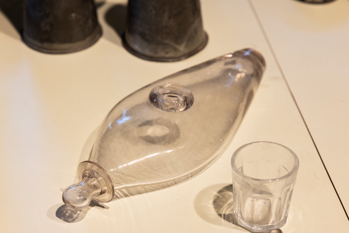 An early bottle for feeding babies or adults in need made of glass on a table