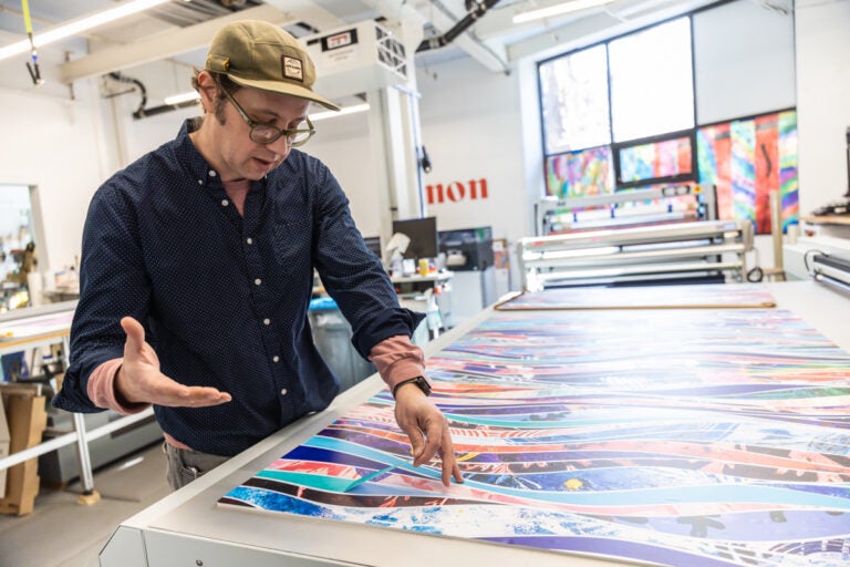 Roger Allen looking at a table of art