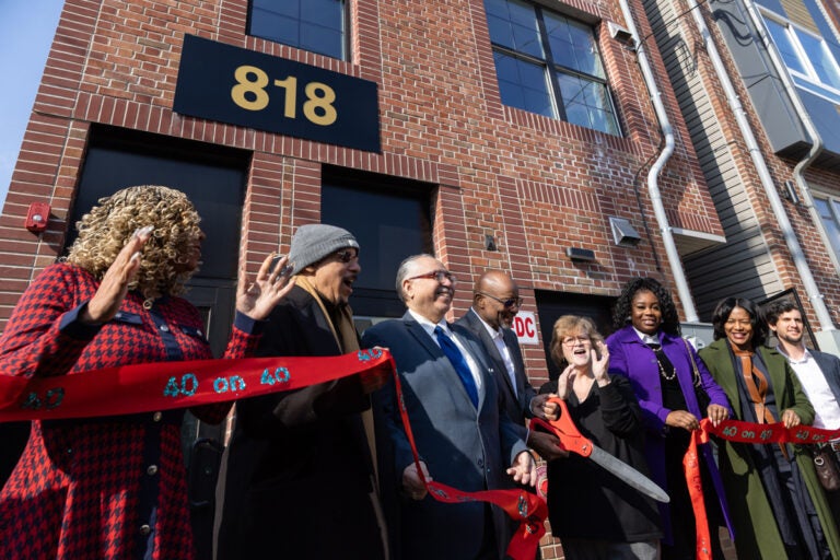 Many officials cut the ribbon at the outdoor ceremony with oversized scissors