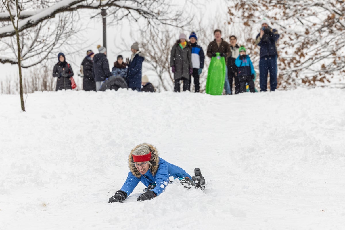 A woman sledding down a hill at the Philadelphia Art Museumafter a snowstorm